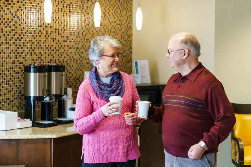Elderly couple having coffee and talking in a skilled nursing facility