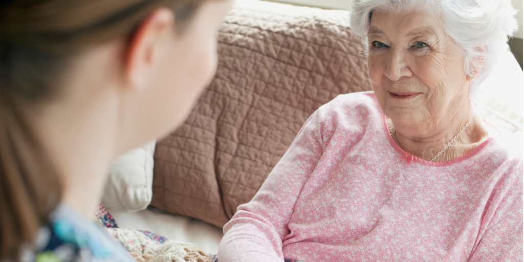 A woman with dementia receives new pajamas as a gift from a young woman