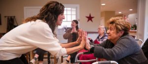 A senior living resident engages with a licensed dance therapist in a Living Branches Memory Care community.