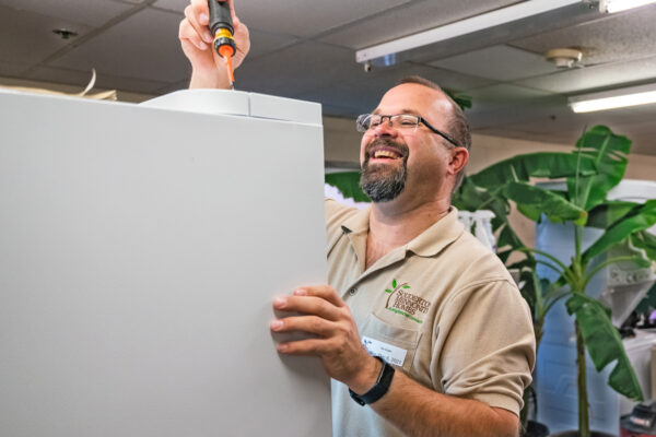 A Living Branches team member provides maintenance on a refrigerator in a Personal Care community